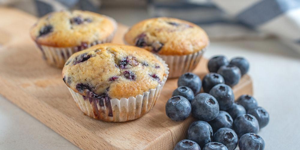 Fluffige Heidelbeermuffins garniert mit frischen Blaubeeren nach Blaubeermuffins Rezept